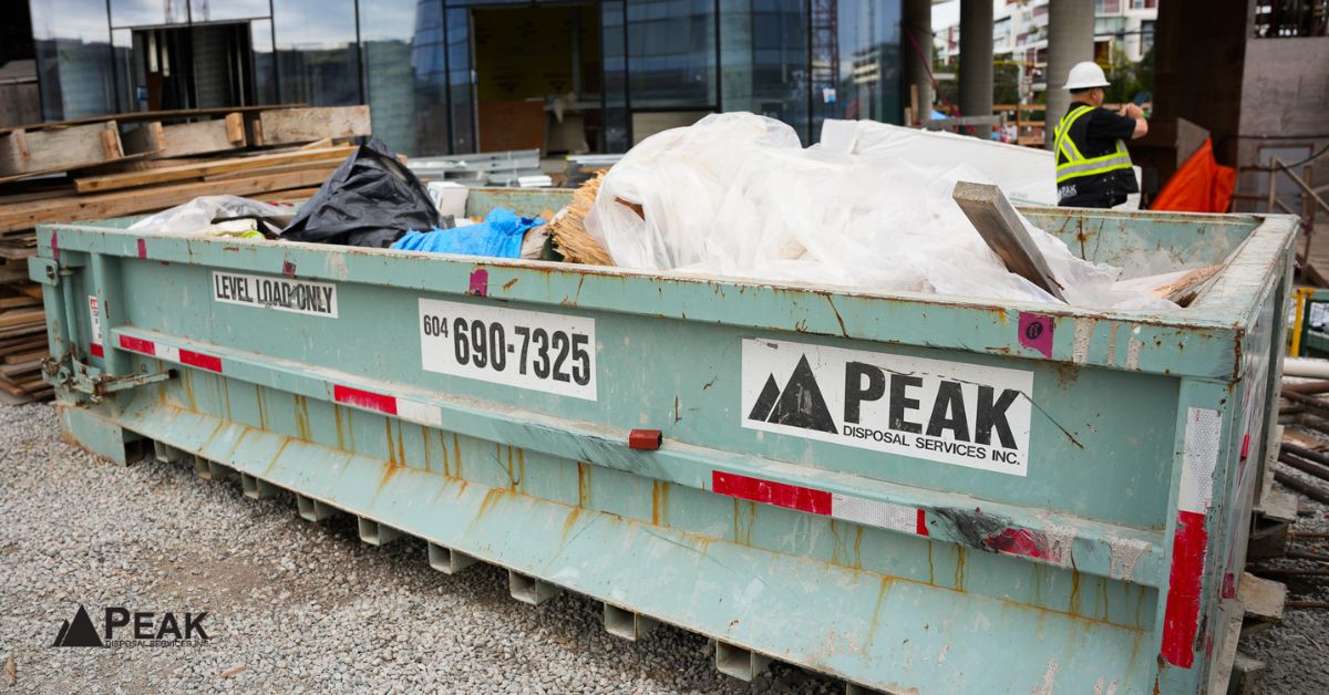 Construction dumpster supporting organized waste diversion tracking at Vancouver building site with separated materials and contractor coordination.