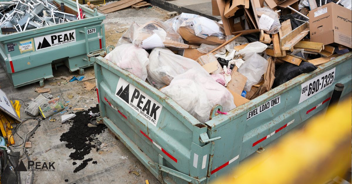 Construction waste bins with separated wood, cardboard, and mixed debris supporting efficient transfer station recycling and processing operations.