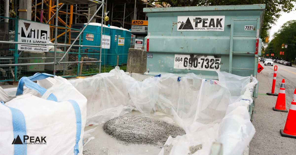 Concrete or dirt bin rental with lined clean fill bags at an urban construction site for heavy debris.