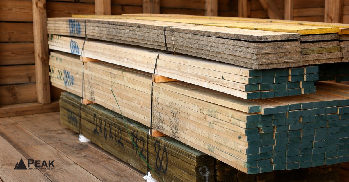 Stacked treated lumber boards with protective coatings stored indoors for durable outdoor construction and moisture-resistant applications.