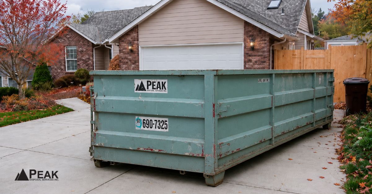 Roofing dumpster placed in a residential driveway to improve loading access and reduce cleanup hazards.
