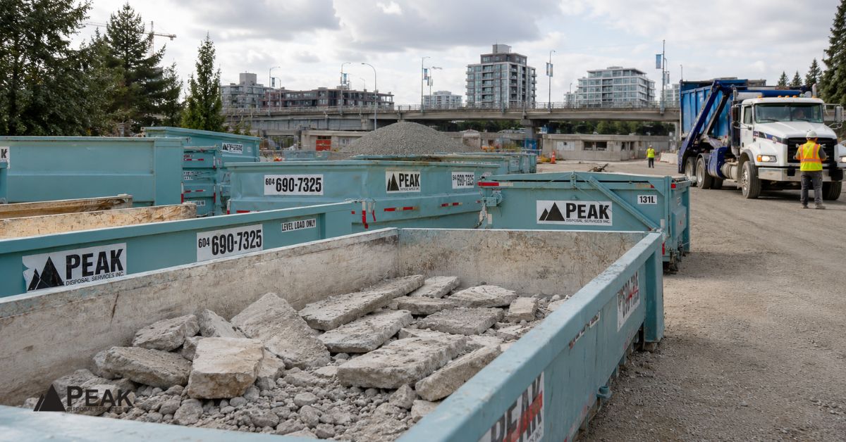 Peak Disposal concrete bins hold separated rubble while crews coordinate hauling at a Metro Vancouver construction site.